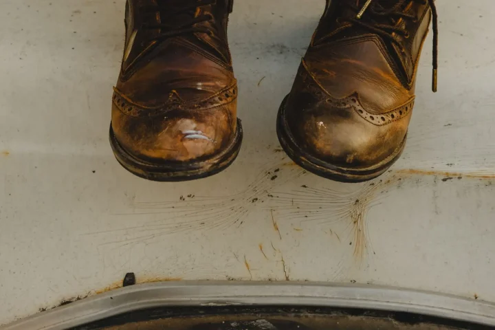Person lacing up brown leather boots